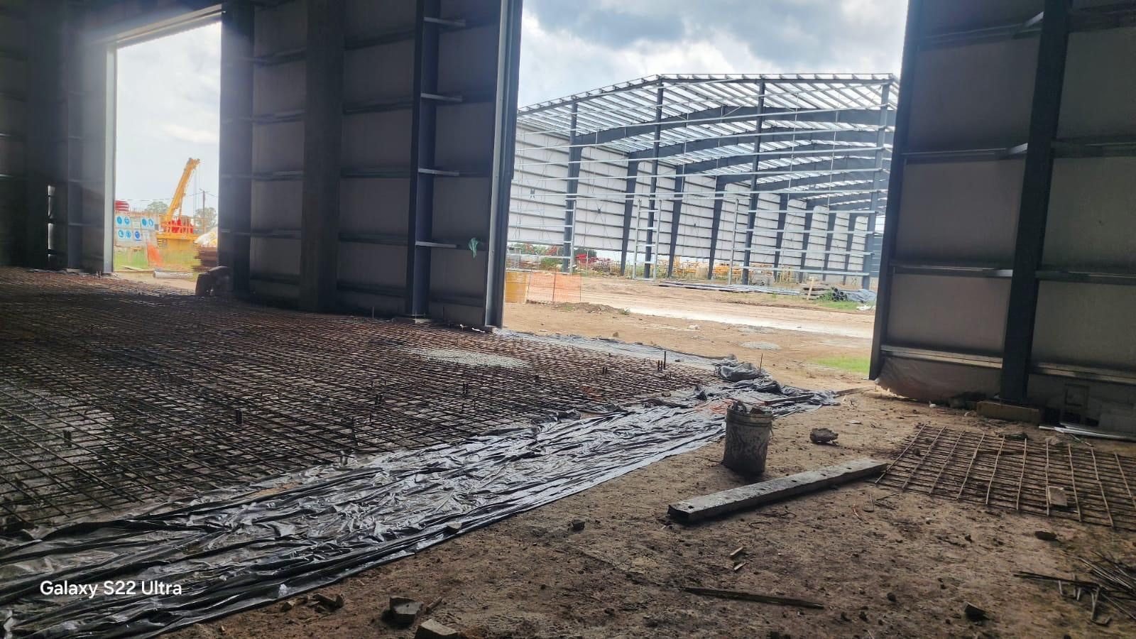 Galpón terminado junto a estructura en montaje