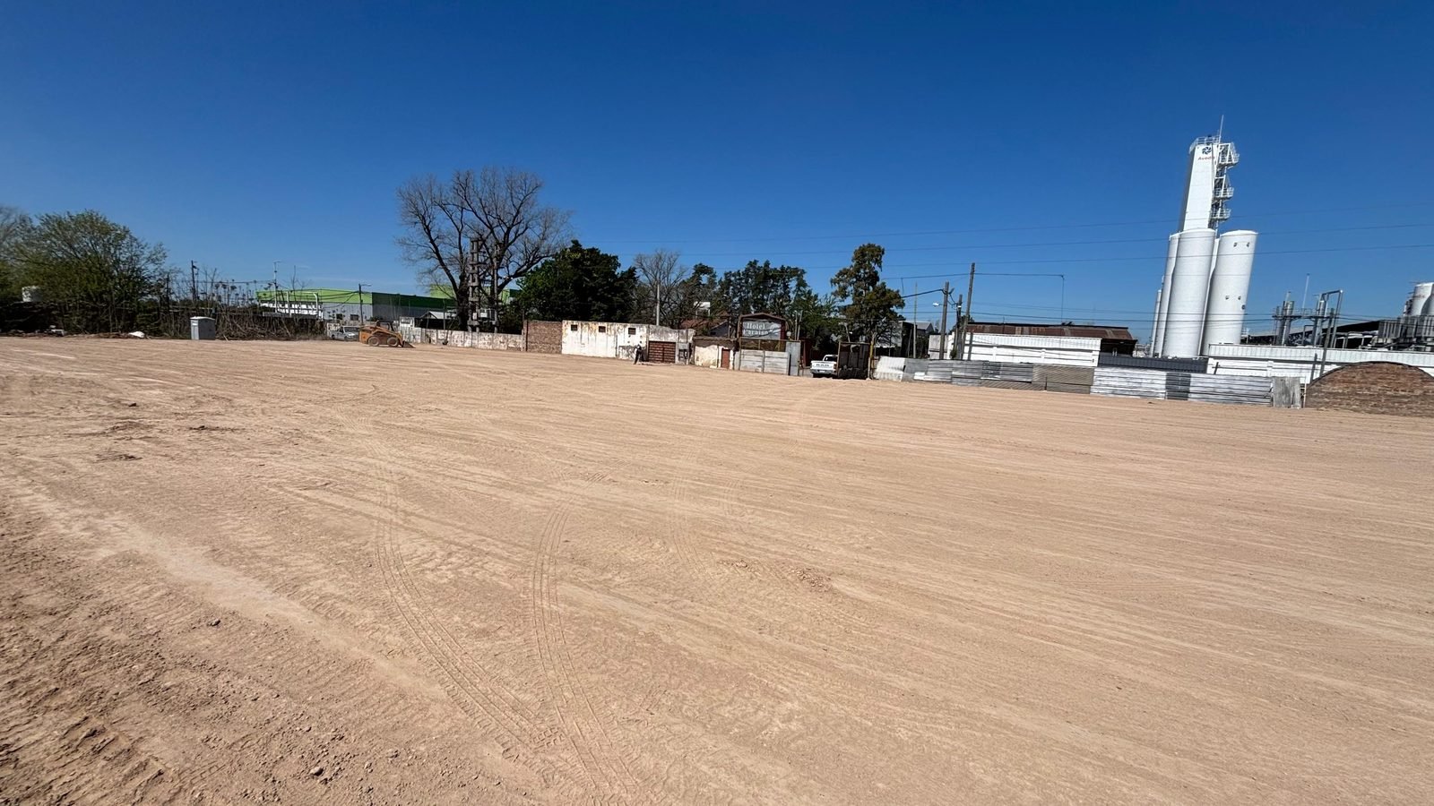 Terreno nivelado con planta industrial al fondo